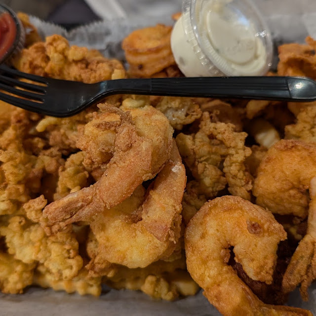 A platter of fried shrimp with hushpuppies