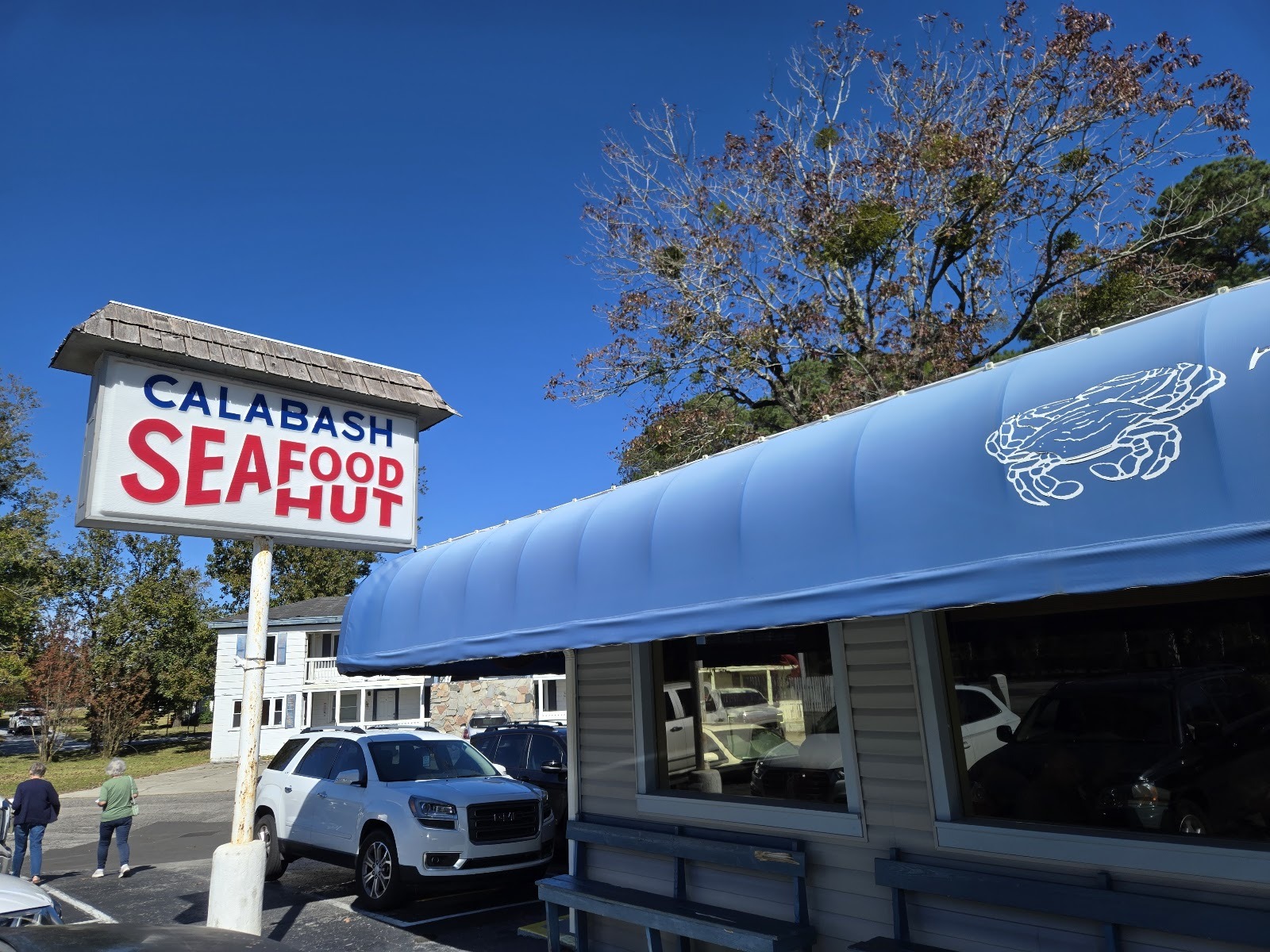 The blue-awning storefront of Calabash Seafood Hut on River Road in Calabash, North Carolina